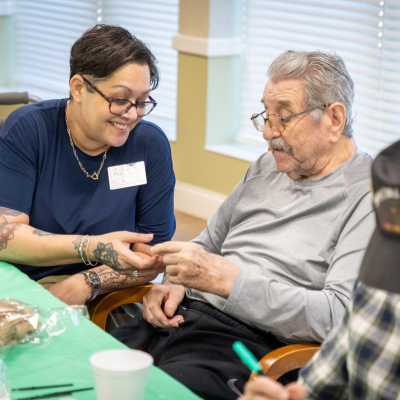 A life enrichment asssitant works with a resident doing an art activity.
