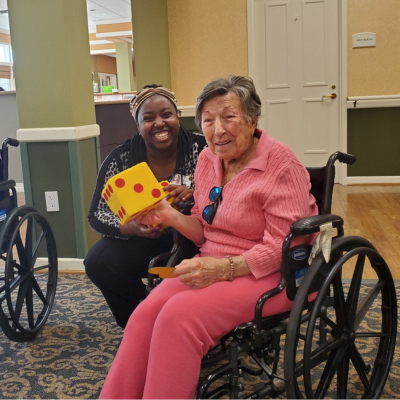 A life enrichment assistant with resident during an activity in the memory center.